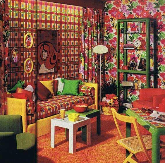 Colorful living room with patterned wallpaper, sofa, shelving, and a white coffee table