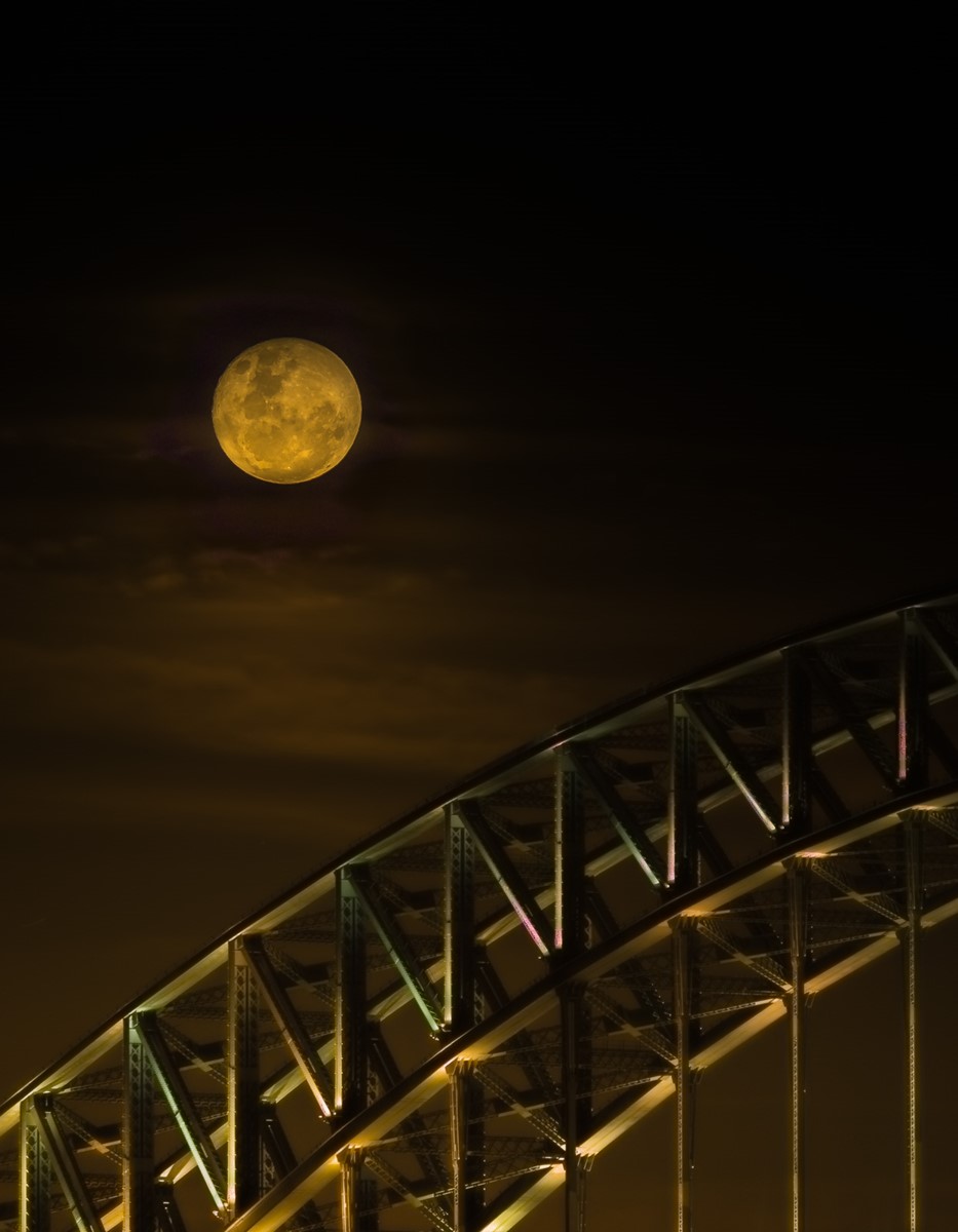 Full moon above the arch of Sydney Harbour Bridge at night