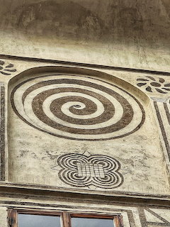 Old building facade with a spiral symbol and decorative plaster patterns