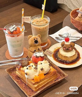 Cafe table with bear-shaped desserts, iced beverages, and pastries on wooden trays