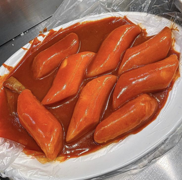 Bowl of glossy orange-red Korean tteokbokki rice cakes in spicy sauce