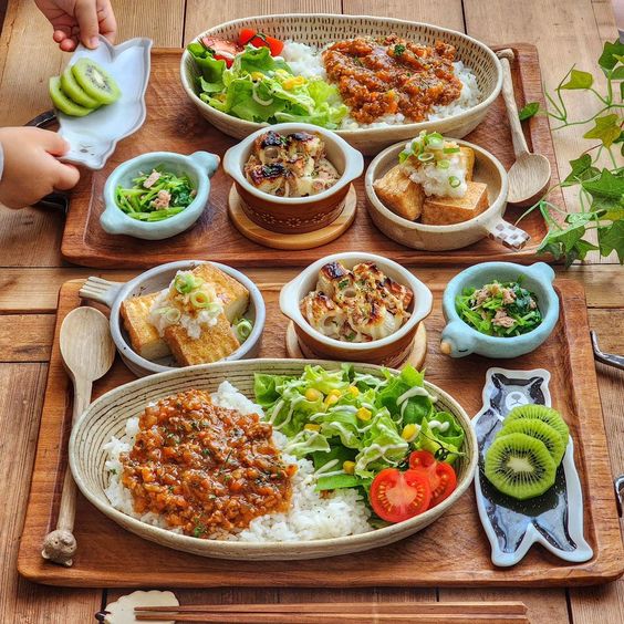 Japanese meal set with rice, grilled meat, salad, soup and side dishes on wooden table