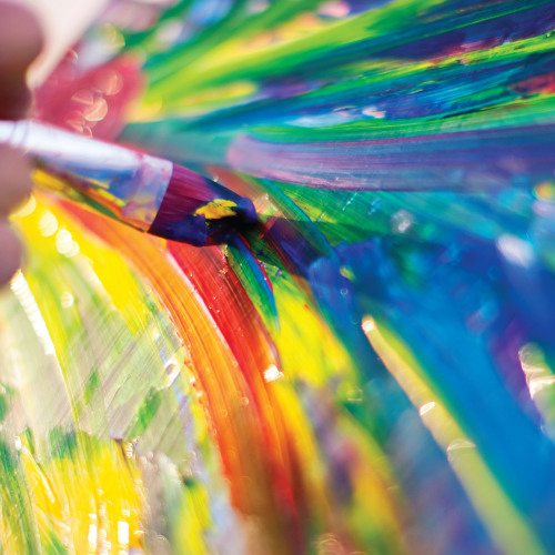 Close-up of vibrant rainbow paint swirls with iridescent colors and dynamic brush strokes
