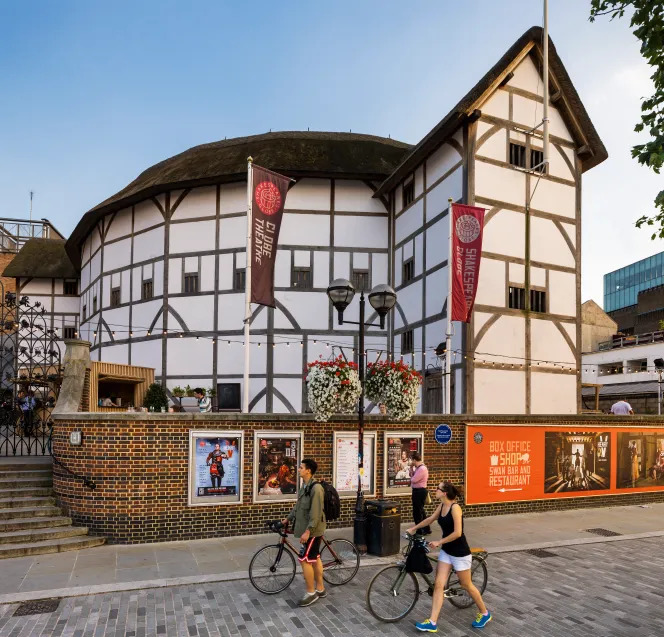 Shakespeare's Globe Theatre in London with pedestrians walking past the timber-framed building