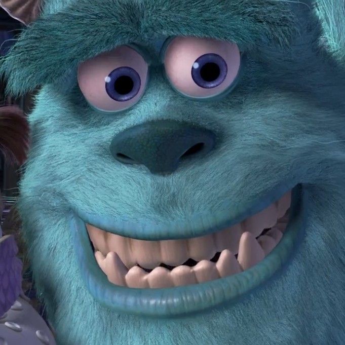 Close-up of Sulley, a blue furry animated monster smiling with big eyes and teeth