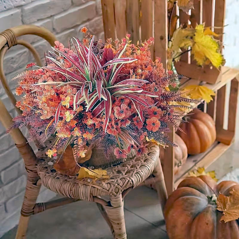 Autumn floral arrangement on a wicker chair with pumpkins and yellow leaves on a porch