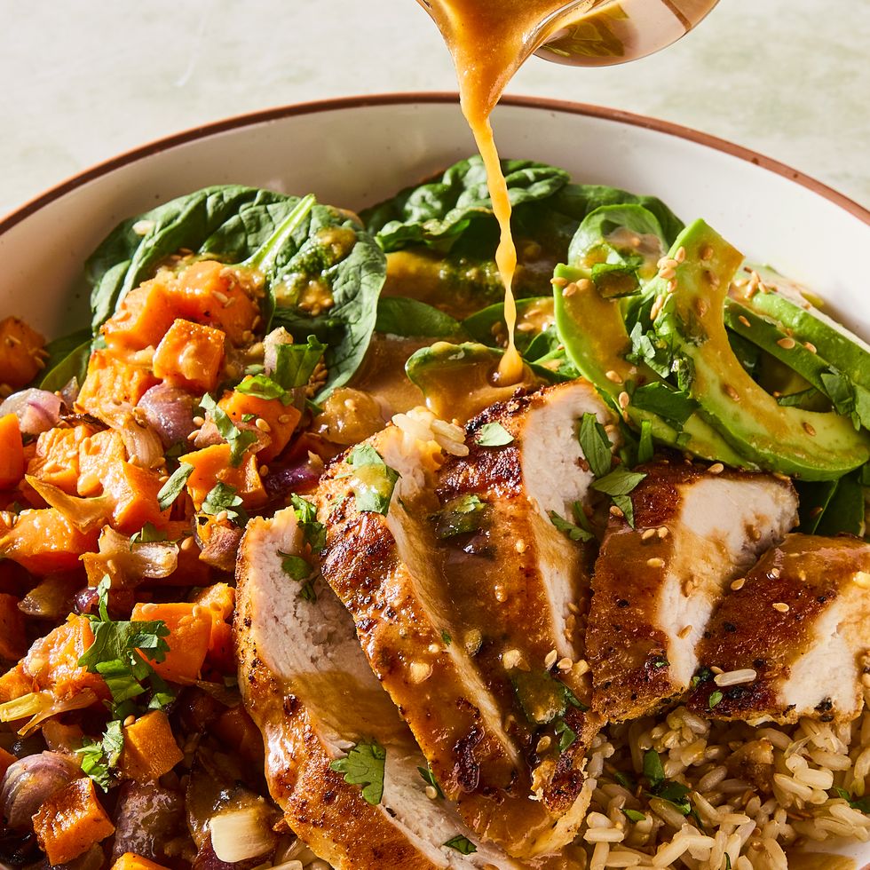 Grilled chicken bowl with peanut sauce, brown rice, roasted vegetables, and greens