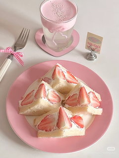 Strawberry cream sandwiches with whipped cream and fresh strawberries on a pink plate with a pink beverage