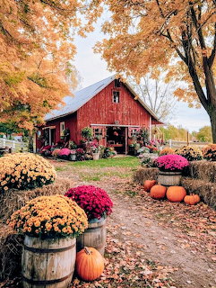 Red barn with pumpkins and fall flowers under orange autumn trees
