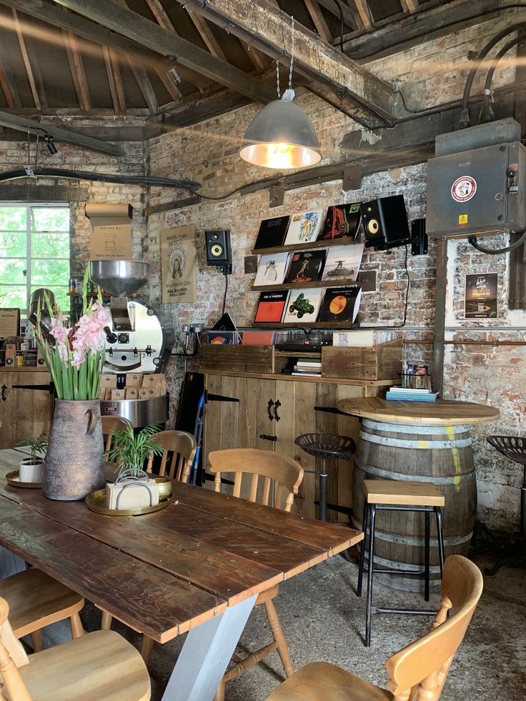 Rustic cafe interior with brick walls, wooden tables, chairs, and vinyl records displayed on wall