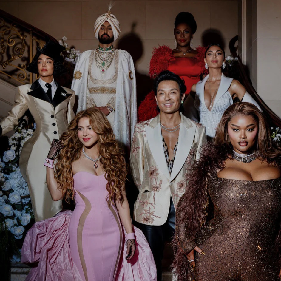 Six fashionably dressed people posing indoors on and near a staircase