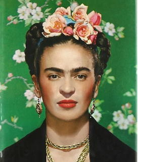 Portrait of Frida Kahlo with pink flowers in her hair against a green floral backdrop