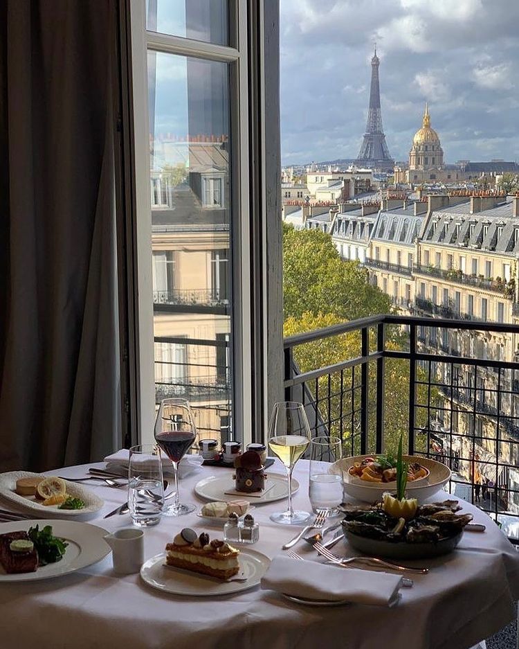 Breakfast table by window overlooking Paris rooftops and Eiffel Tower