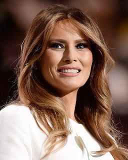 Portrait of smiling woman with long brown hair in white clothing