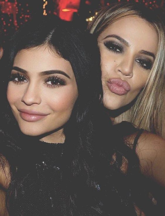 Two young women posing for a selfie at an indoor event, one with dark hair and one with blonde hair