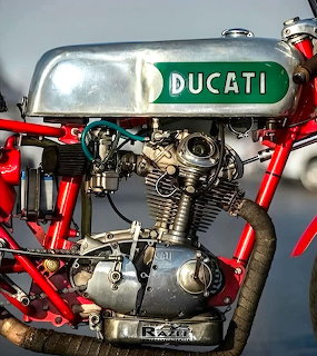 Vintage Ducati racing motorcycle engine close-up with red frame and silver fuel tank
