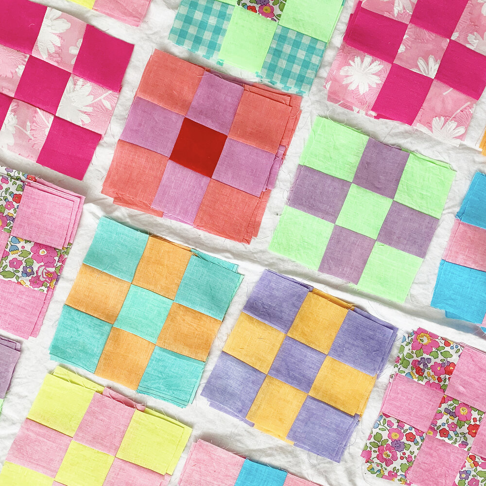 Colorful patchwork quilt with checkered squares in various pastel colors and floral patterns