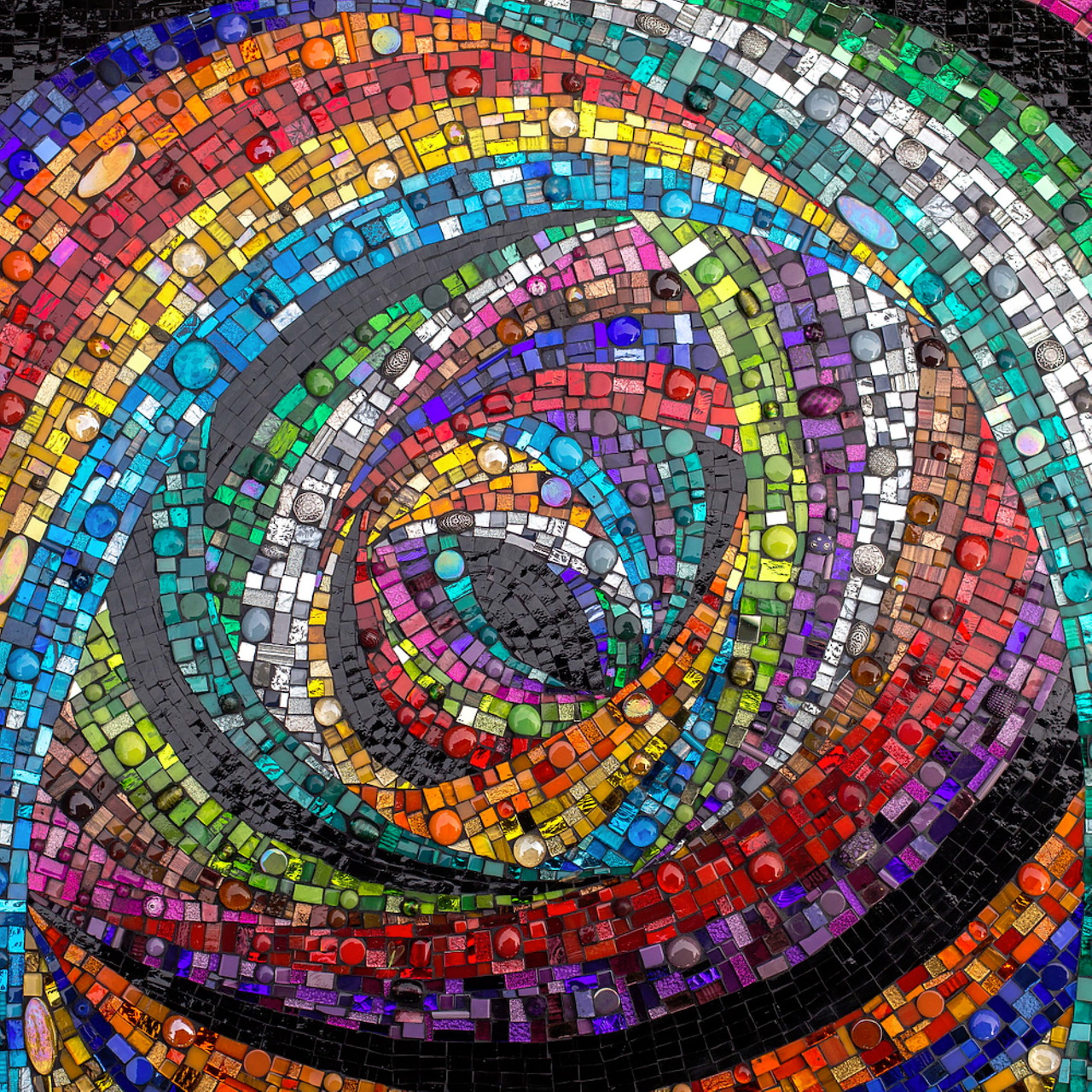 Colorful mosaic spiral pattern with rainbow tiles swirling from center outward
