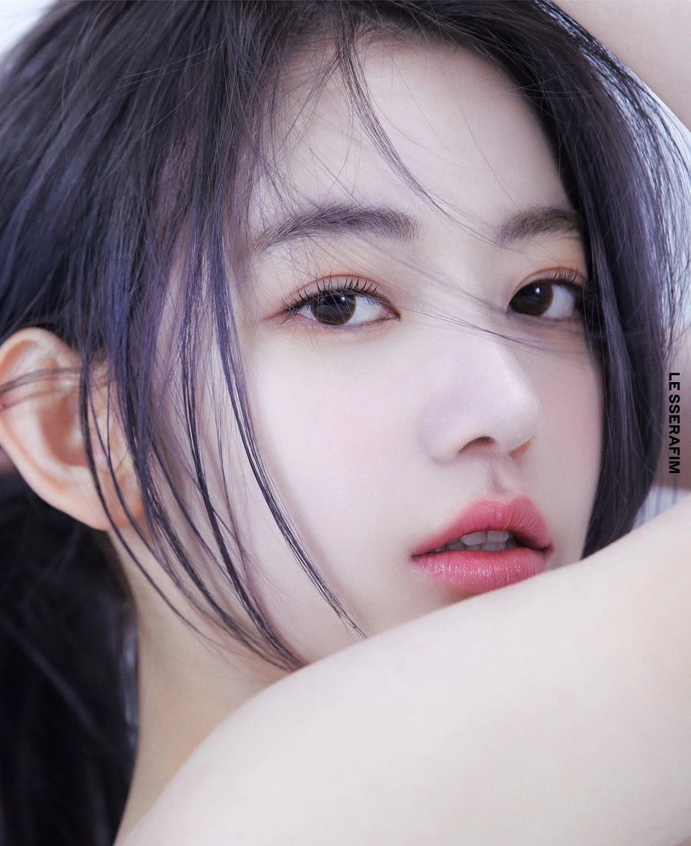 Close-up portrait of Sakura from LE SSERAFIM with purple-tinted dark hair and soft makeup