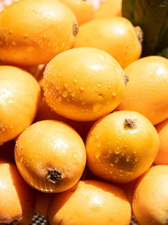 Pile of ripe yellow mangoes with water droplets on their skin