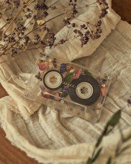 Clear cassette tape with floral design on cream linen cloth with dried lavender on wooden table