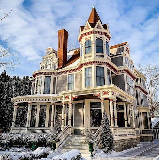 Victorian mansion with turrets and ornate details in winter snow