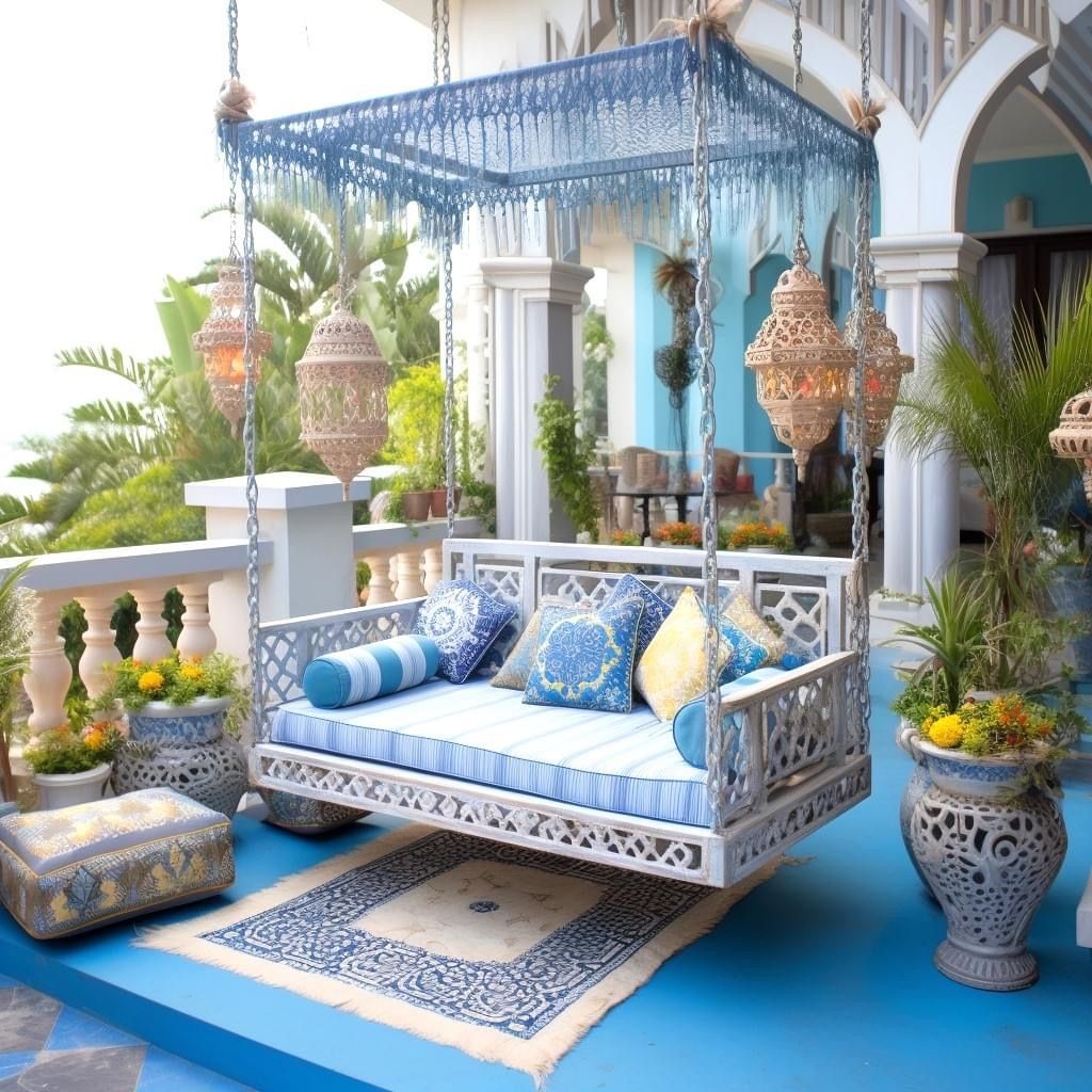 Blue tropical patio with a hanging daybed, lanterns, patterned cushions, and lush potted plants
