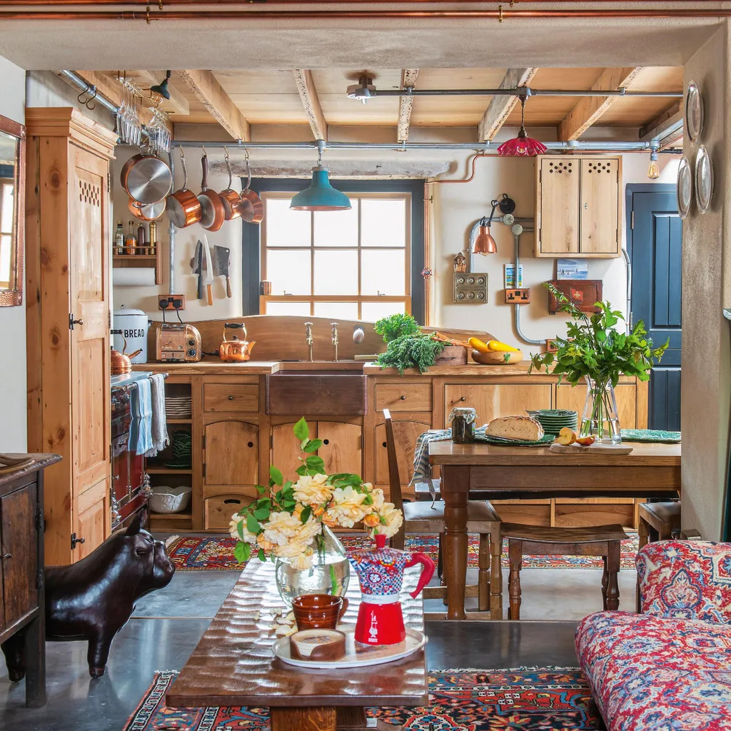 Rustic wooden kitchen interior with dining table, plants, window, and floral sofa