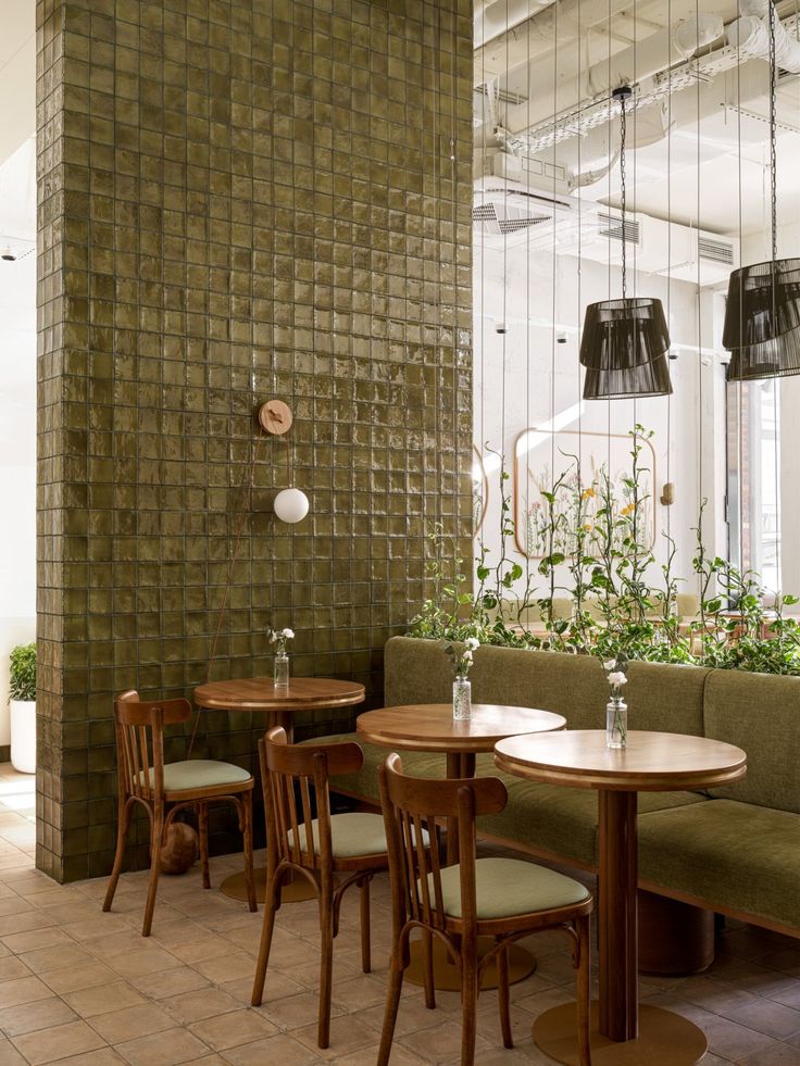 Cozy restaurant interior with green walls, wooden tables and vintage pendant lights