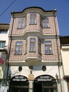 Ornate multi-story building with decorative brick facade and bay windows in Veliko Tarnovo, Bulgaria