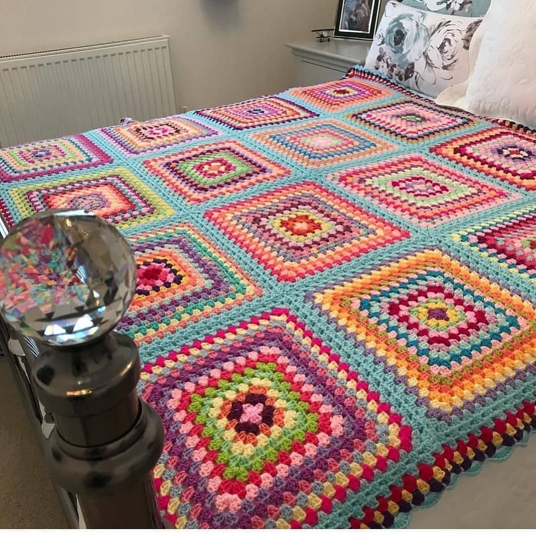 Colorful crochet granny square bedspread on a bed in a bedroom