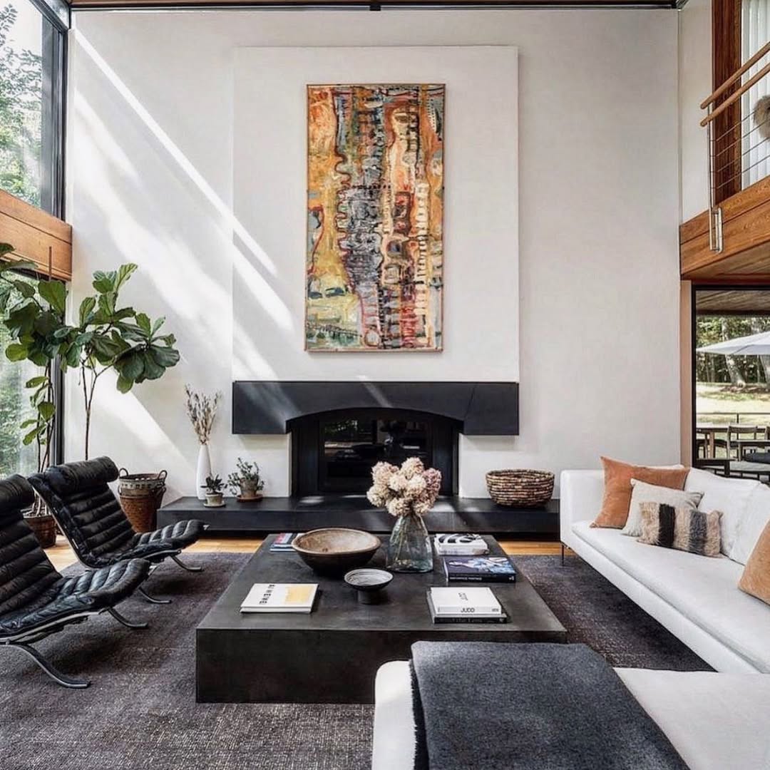 Modern living room with fireplace, abstract wall art, black coffee table, and white sofa