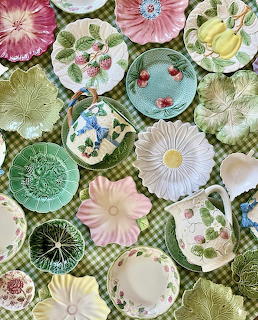 Collection of vintage floral and botanical decorative plates on green checkered tablecloth
