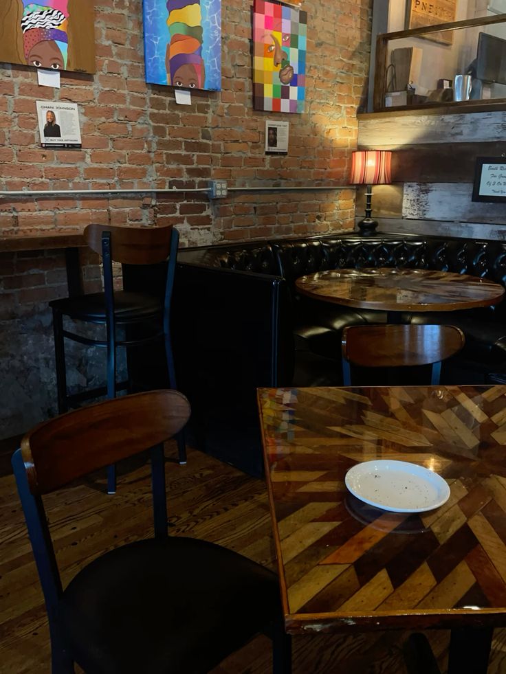 Modern coffee shop interior with brick walls, wooden furniture, and colorful wall art