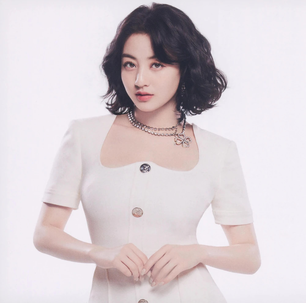 Studio portrait of a young woman with short dark wavy hair in a white dress