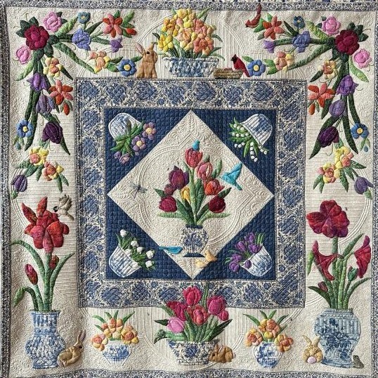 Handmade quilt with tulips and spring flowers in diamond layout with blue geometric border
