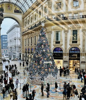Large Christmas tree in ornate glass-roofed Milan shopping gallery with crowds