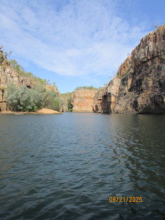 Boat cruise view of Katherine Gorge with red cliffs and calm water under blue sky