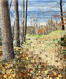 Quilted fabric art showing an autumn forest with bare trees, fallen leaves, and a woodland path