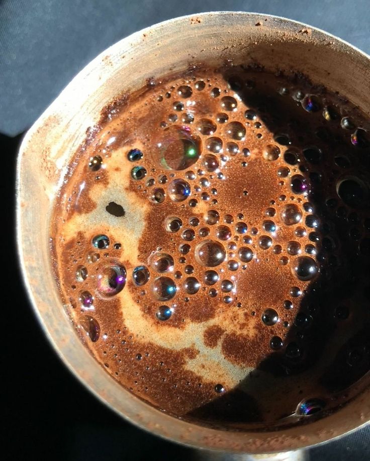 Top view of a cup of coffee latte with foamy brown crema and bubbles