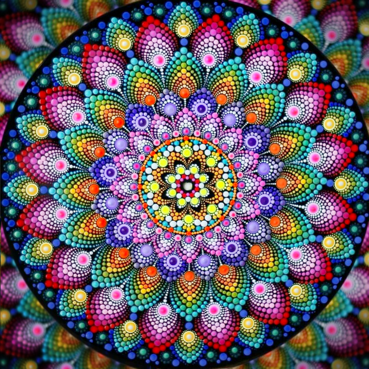 Vibrant dot mandala with rainbow colored concentric circles radiating from yellow center on dark background