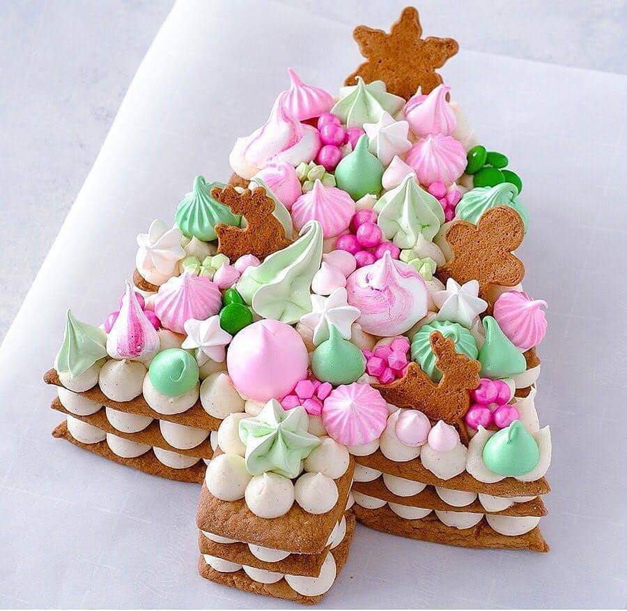 Christmas tree cookie cake with pink and green meringue, gingerbread stars, arranged in tree shape