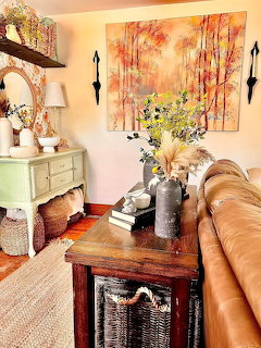 Cottage living room with floral curtains, wooden table, cream sofa and warm ambient lighting