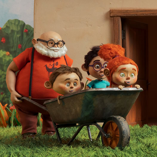 Stylized grandfather next to a wheelbarrow with three children outside near a house