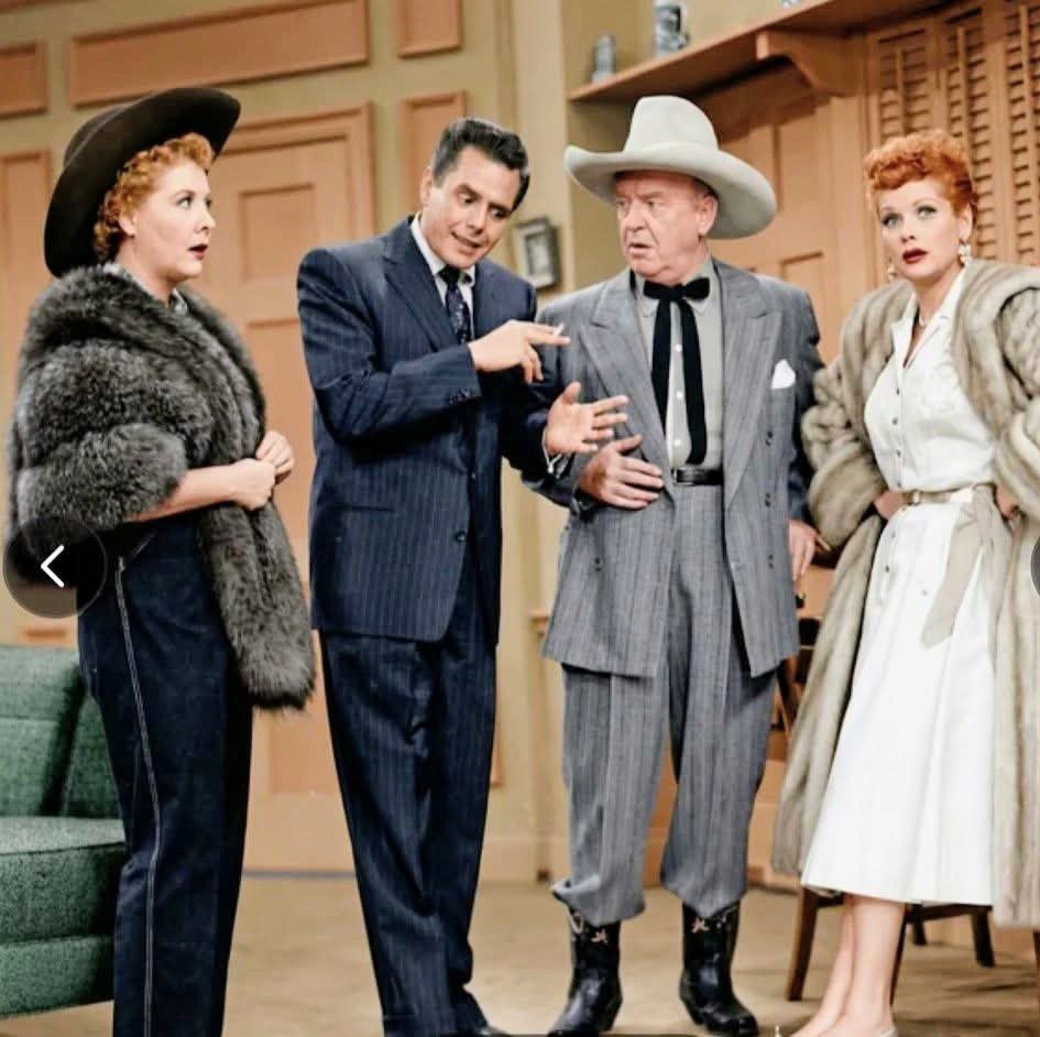 Vintage TV scene with four people standing indoors in formal clothing