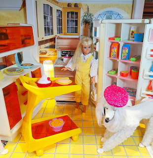 Barbie doll in miniature kitchen with yellow furniture and vintage appliances