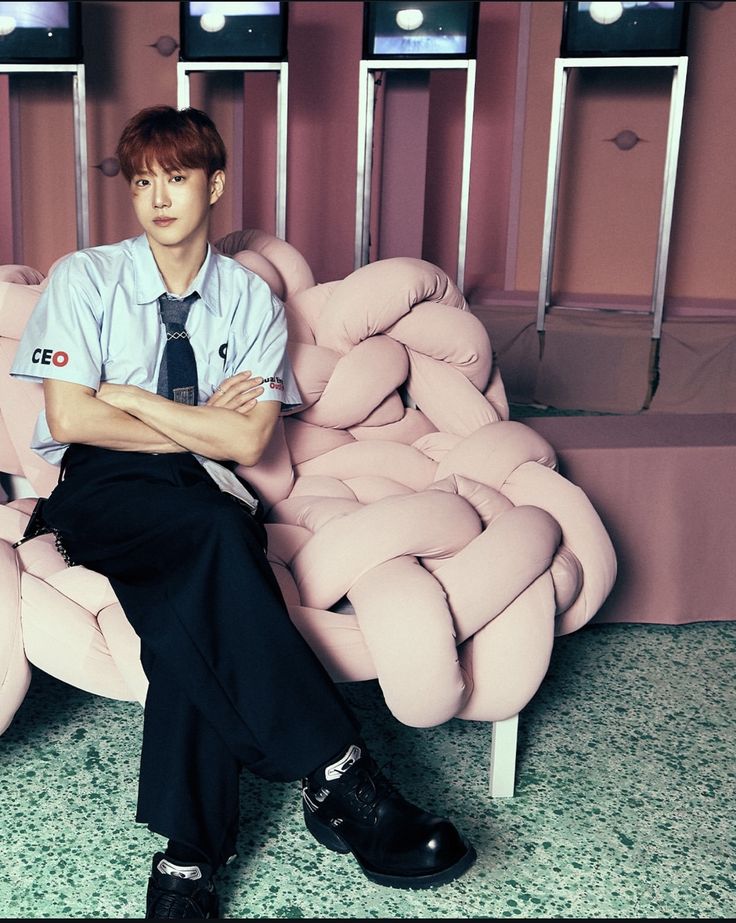 Man in white shirt sitting on pink velvet armchair in modern interior