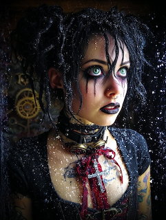 Gothic woman with black eye makeup, wet dark hair, and crucifix necklace looking intensely at camera