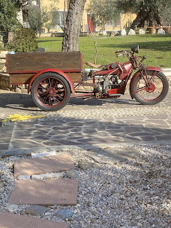 Red vintage cargo motorcycle with wooden rear bed parked outdoors