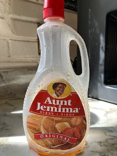 Plastic syrup bottle on a marble countertop beside a microwave